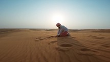 Woman throws desert sand into the air