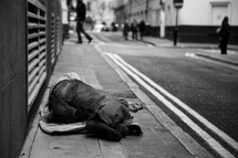 Homeless man sleeping on sidewalk