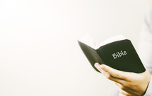 person holding a pocket Bible 