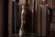 wooden human figurines and old books 