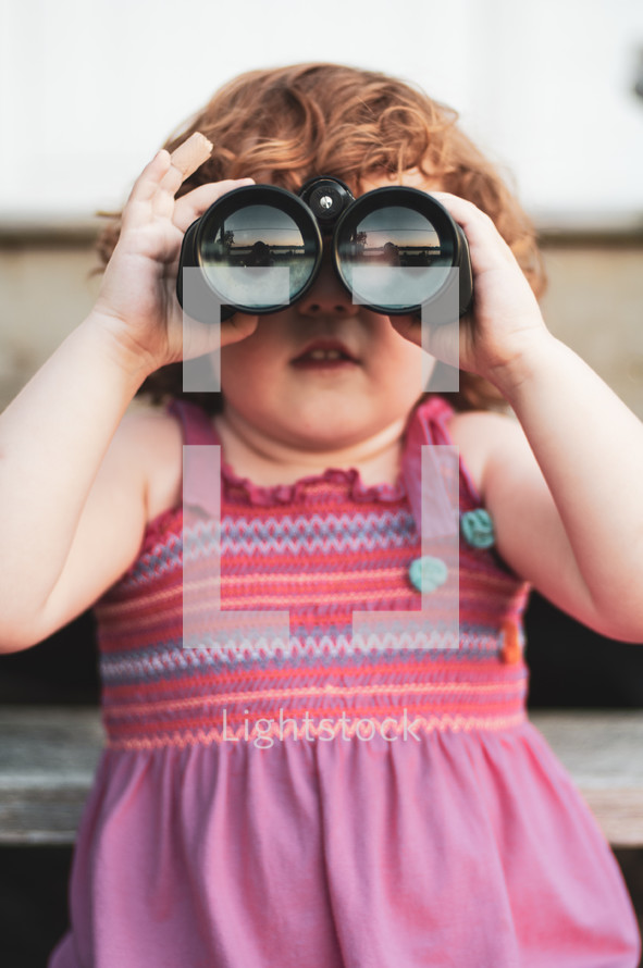 a child looking through binoculars 