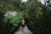 a woman walking down steps into a jungle 