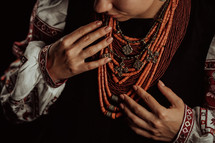 Demonstrating traditional antique jewelry necklace. National costume of Ukraine. Ukrainian woman in legacy ancient coral beads, Zgarda - archaic hutsul neck ornament of status religious purpose.