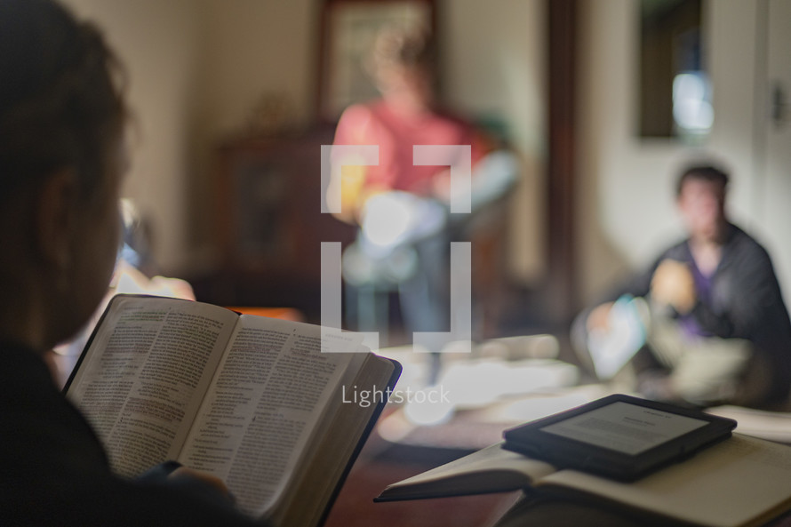 close up of young woman holding open her Bible  in a small group study