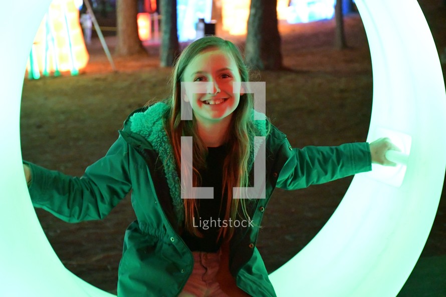 smiling child sitting on a glowing swing at a Chinese Lantern festival 