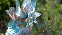 closeup of a pinwheel outdoors with sun shining on it and a blurred background