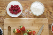 cutting board, knife, strawberries, and raspberries 