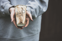 a woman holding a cup with the word help 