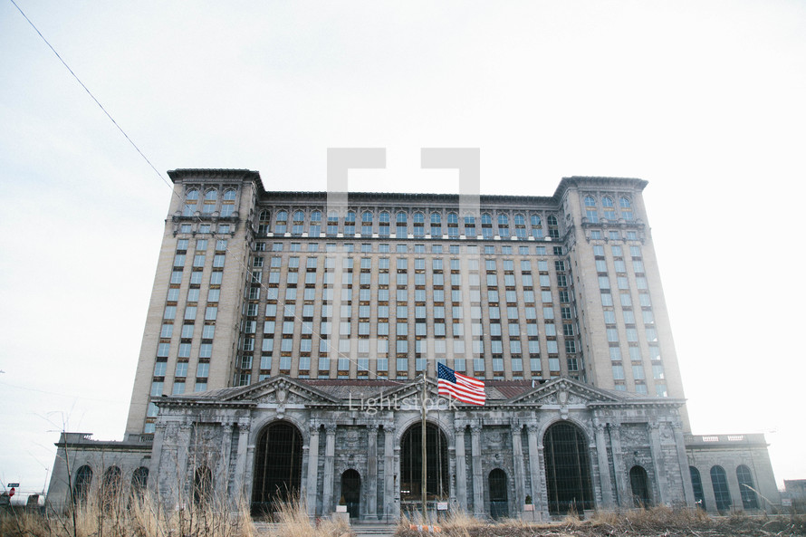 American flag in front of an abandoned city building 