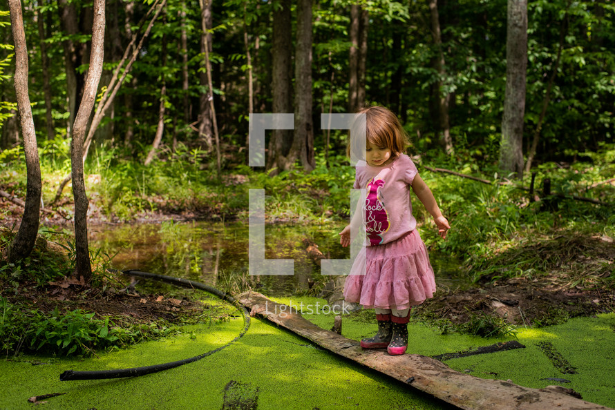 little girl exploring a pond 