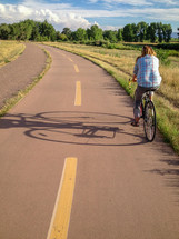 a woman biking on a trail 
