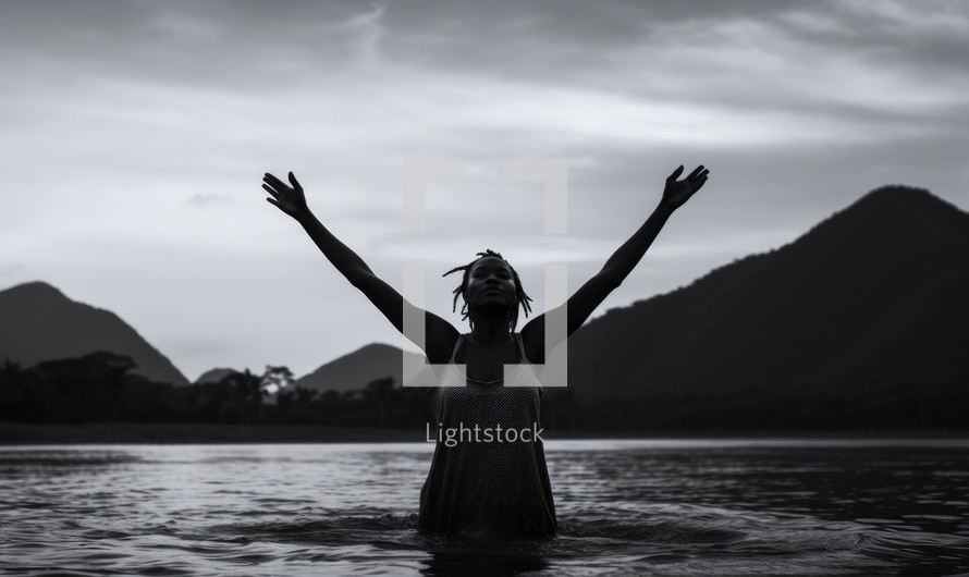 Baptism. Silhouette of a black woman in the water. Black and white.