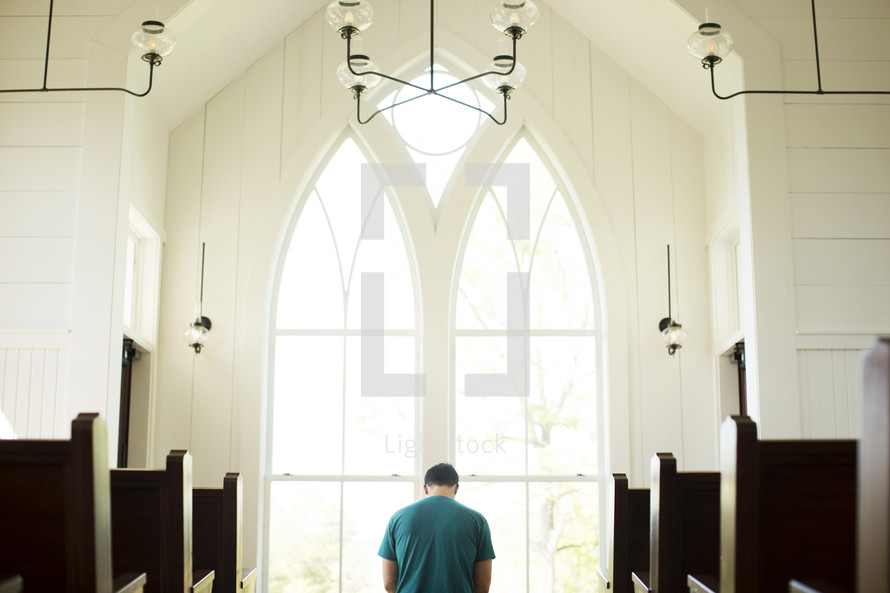 a man kneeling in prayer at church 