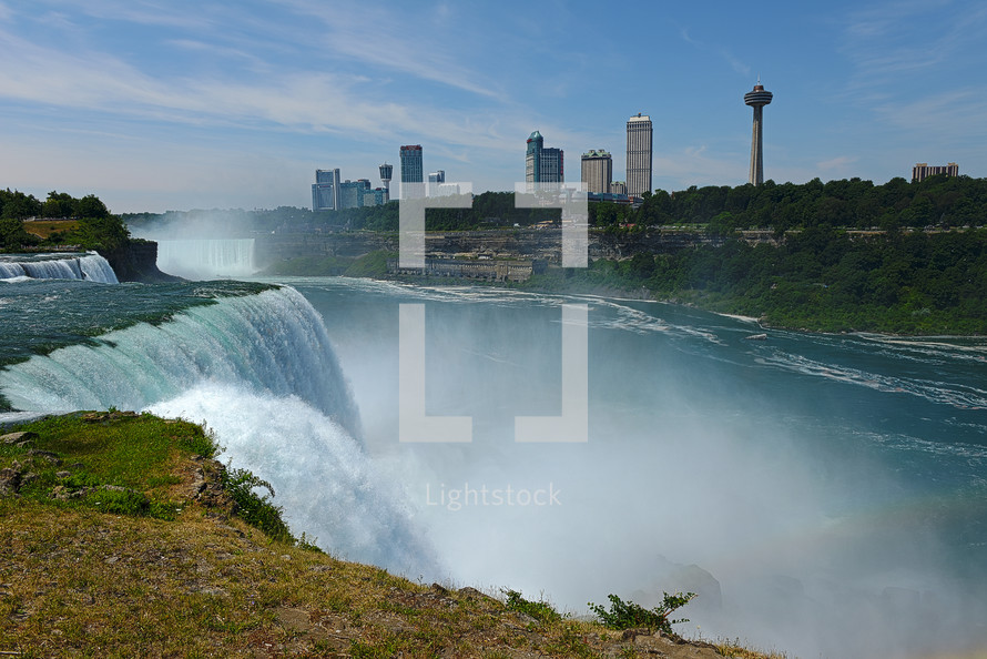 Waterfall with a city skyline in the background.
