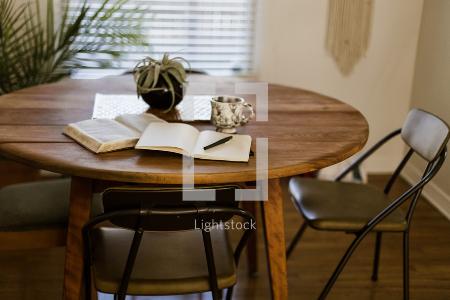 A Bible and journal on a wood table 