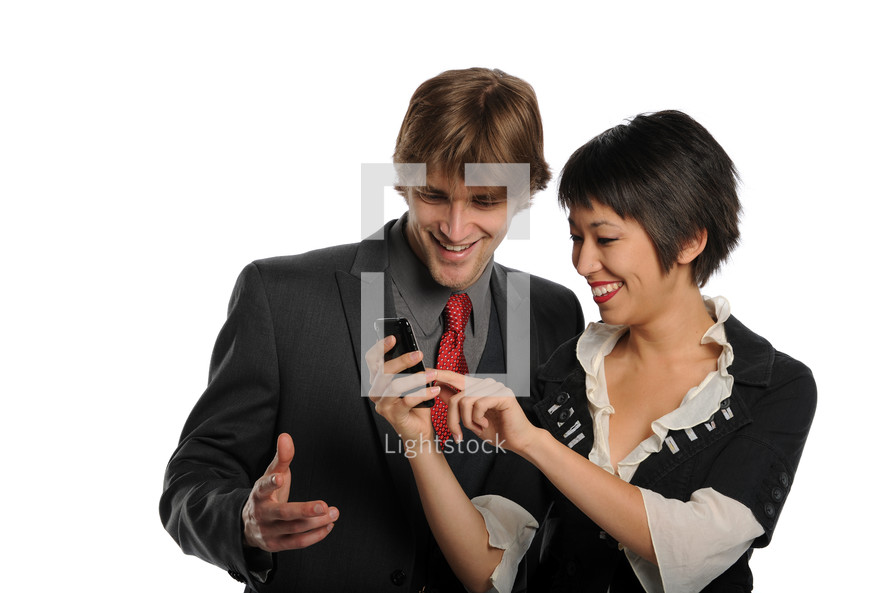 A man and woman looking at a cell phone and smiling.