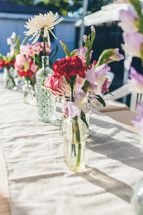 flowers in glass bottles on a table 