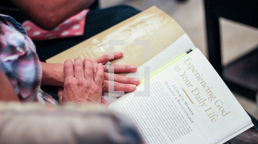 An elderly woman reading a magazine article "Experiencing God in Your Daily Life" 