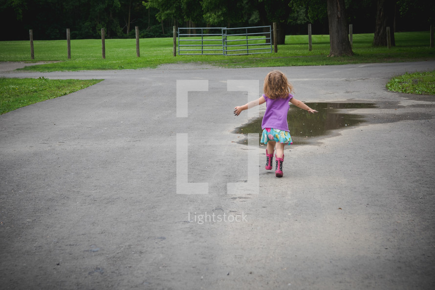 toddler running towards a puddle 