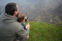 father and son fishing at a pond 