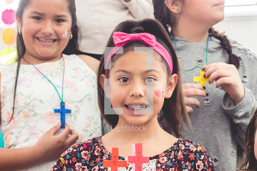 girls holding handmade crosses 