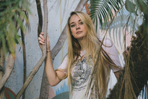 portrait of a blonde woman in a tropical plants 