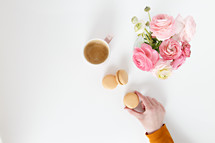 coffee, macaroons and pink flowers in a vase 