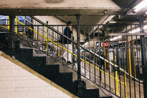 man walking down stairs to a subway