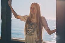 woman with long blonde hair standing near water 