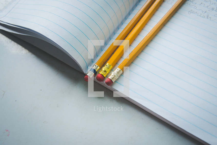 pencils on the pages of a notebook 