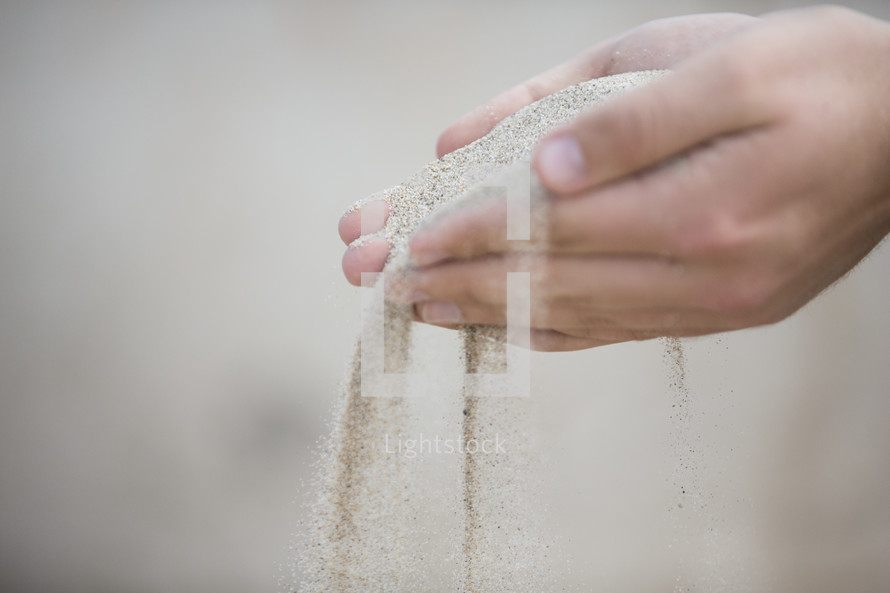 Hands sifting sand