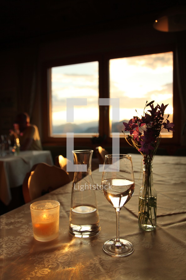 wine glass, wine, wine carafe, candle, window, sunset, flowers, vase