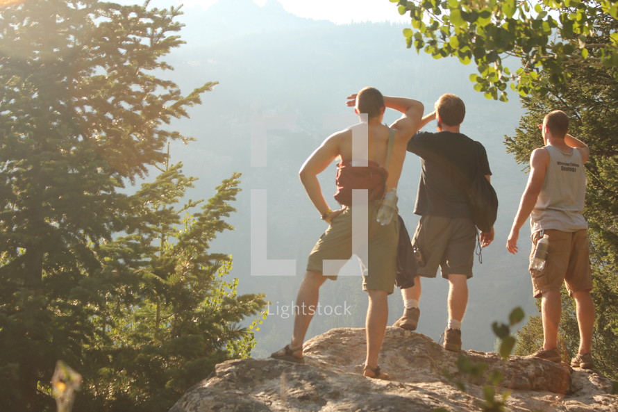 friends taking in the view from a cliff on a mountain 