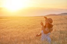a woman standing in a field golden wheat field 
