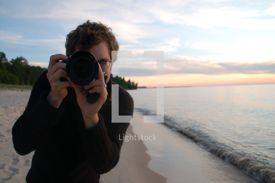 Photographer on the beach at the ocean.