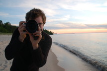 Photographer on the beach at the ocean.