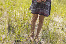 woman's bare feet in tall grass 