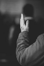 man with hand raised at a worship service 