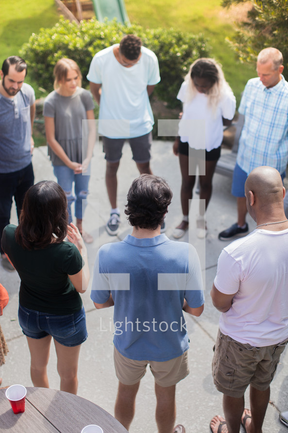 group prayer at an outdoor summer party 