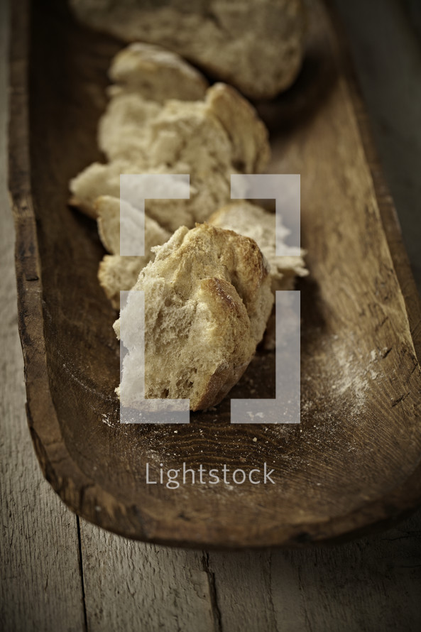 Broken pieces of bread on a wooden tray