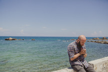 man in prayer at the coast in Greece