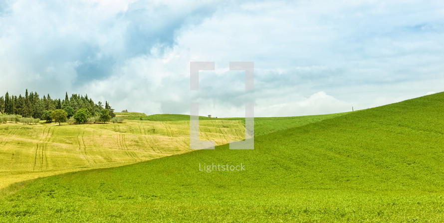 Background of green field with blue sky in Italy