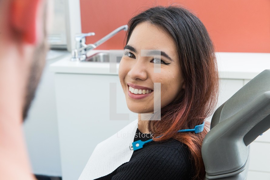 a smiling woman in the dentist chair 
