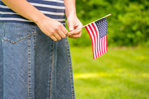 A girl holding a small American flag 
