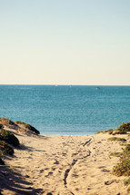 Coastal landscape with thin beach and blue sea.