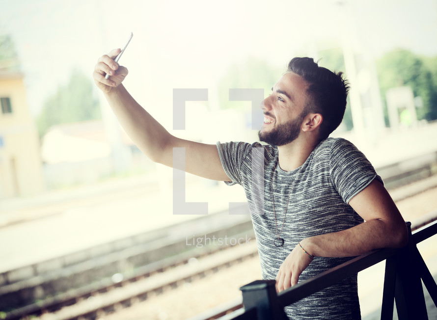 Young Man with smartphone at the train station