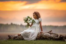 girl in a white dress holding a bouquet of flowers 