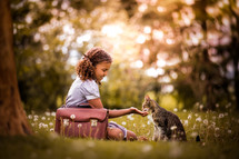a child petting a cat on a summer day 