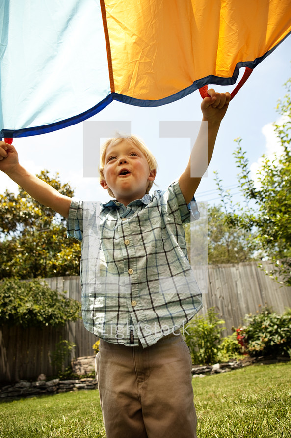 toddler boy holding a parachute