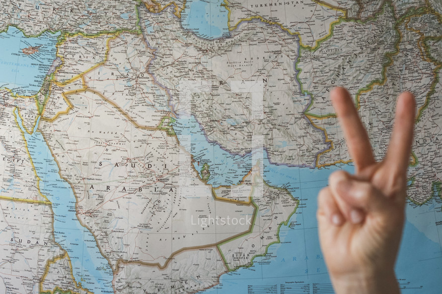peace sign in front of a map of the Middle East